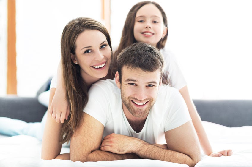smiling family in bed